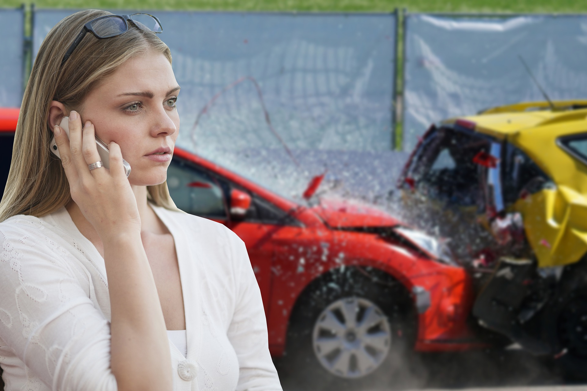 Mujer llamando por teléfono mientras se ve de fondo dos coches colisionando