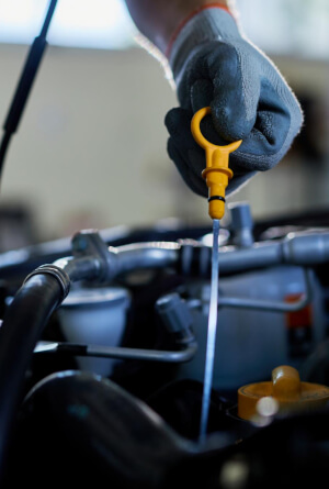 Mecánico comprovando el nivel de aceite en un vehículo